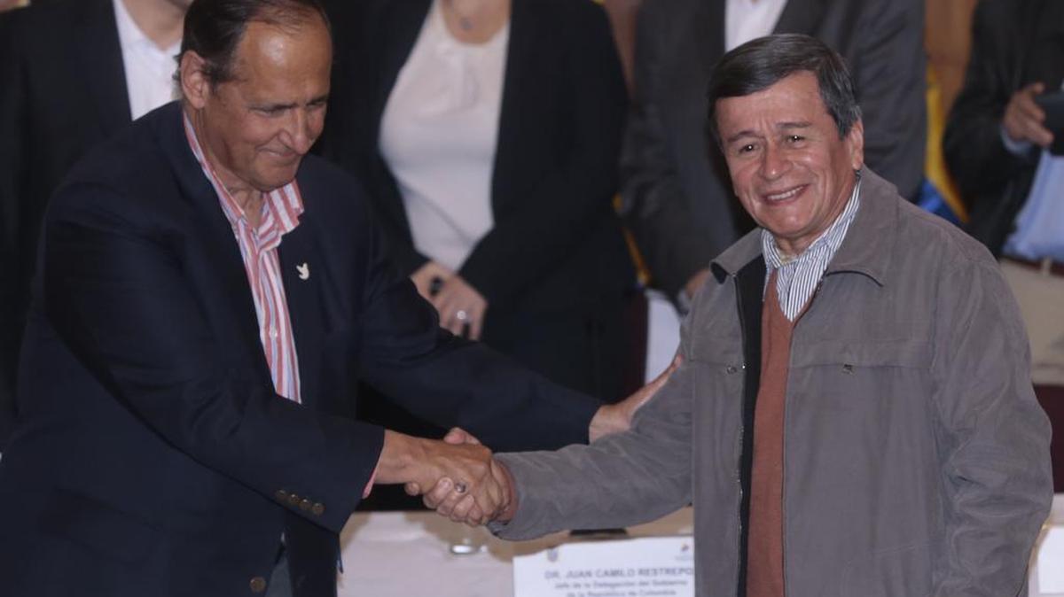 Los representantes del gobierno colombiano, Camilo Restrepo (izq.), y de la guerrilla del ELN, Pablo Beltrán, se saludan durante una conferencia de prensa el miércoles en Quito, Ecuador.