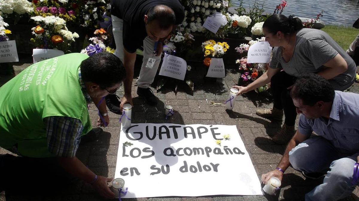 Habitantes dejan velas, flores y carteles el lunes 26 de junio de 2017, como homenaje a las víctimas del naufragio de una embarcación con aproximadamente 170 personas en el embalse de Guatapé municipio al oriente de Antioquia (Colombia).