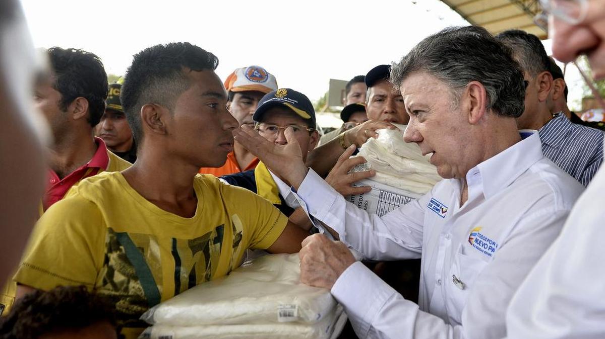 
Fotografía cedida por la presidencia de Colombia del mandatario Juan Manuel Santos (d) mientras saluda a un hombre que recibe ayudas el sábado 29 de agosto de 2015, durante una visita a algunos albergues donde se alojan deportados por las autoridades venezolanas en Cúcuta (Colombia). 
