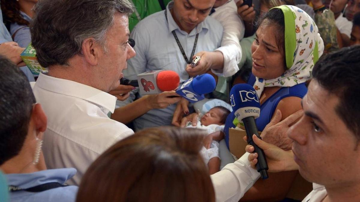 
El presidente de Colombia, Juan Manuel Santos (izq.), habla el miércoles con colombianos deportados desde Venezuela en el albergue del Coliseo Francisco de Paula Santander, en Cucutá. 
