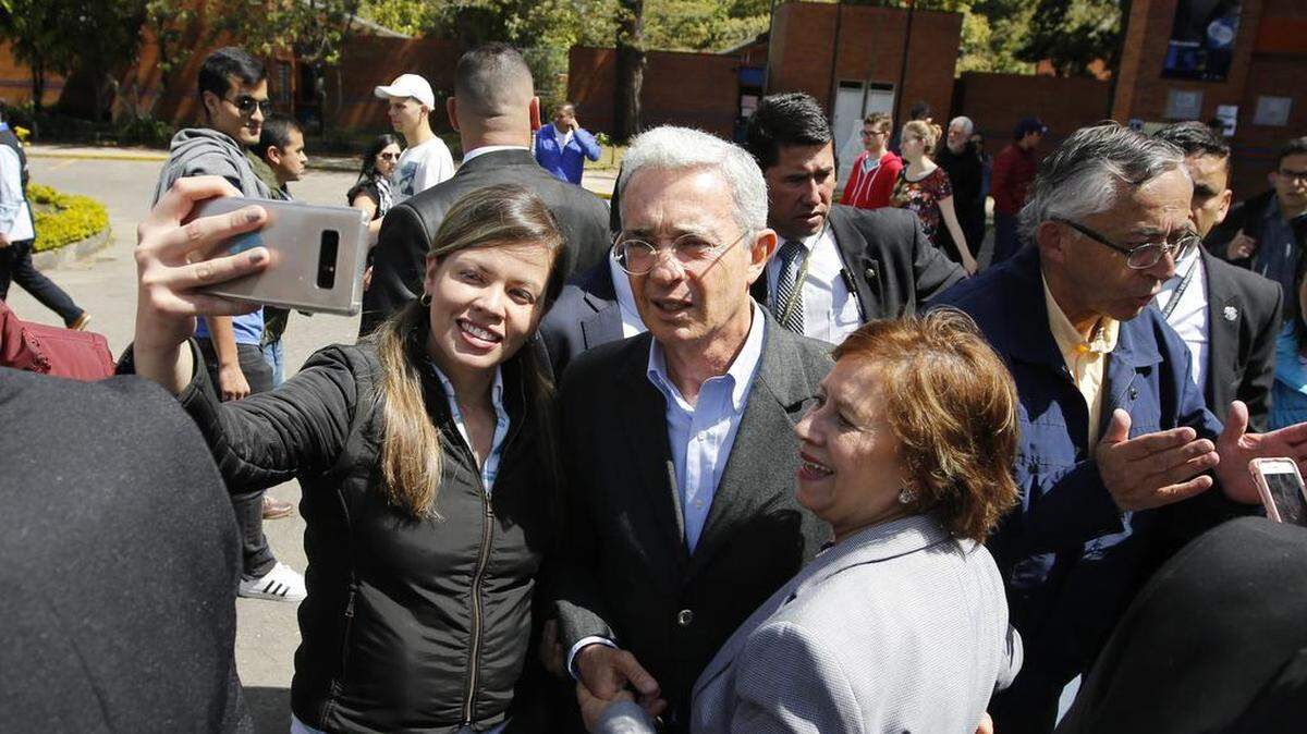 El ex presidente colombiano Álvaro Uribe, candidato a senador por el Partido Centro Democrático, posa para un selfie con sus seguidores mientras acompaña al candidato presidencial de su partido, Iván Duque, a un colegio electoral durante las elecciones legislativas en Bogotá, Colombia, el domingo 11 de marzo. 2018.