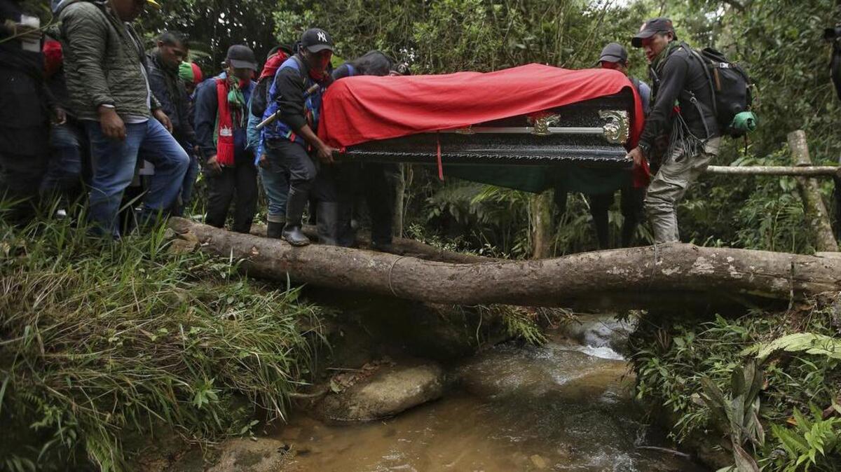 Miembros de la guardia indígena cargan el ataúd de un líder indígena asesinado por ex miembros de las FARC en La Buenos Aires, Colombia, el 27 de enero del 2022.