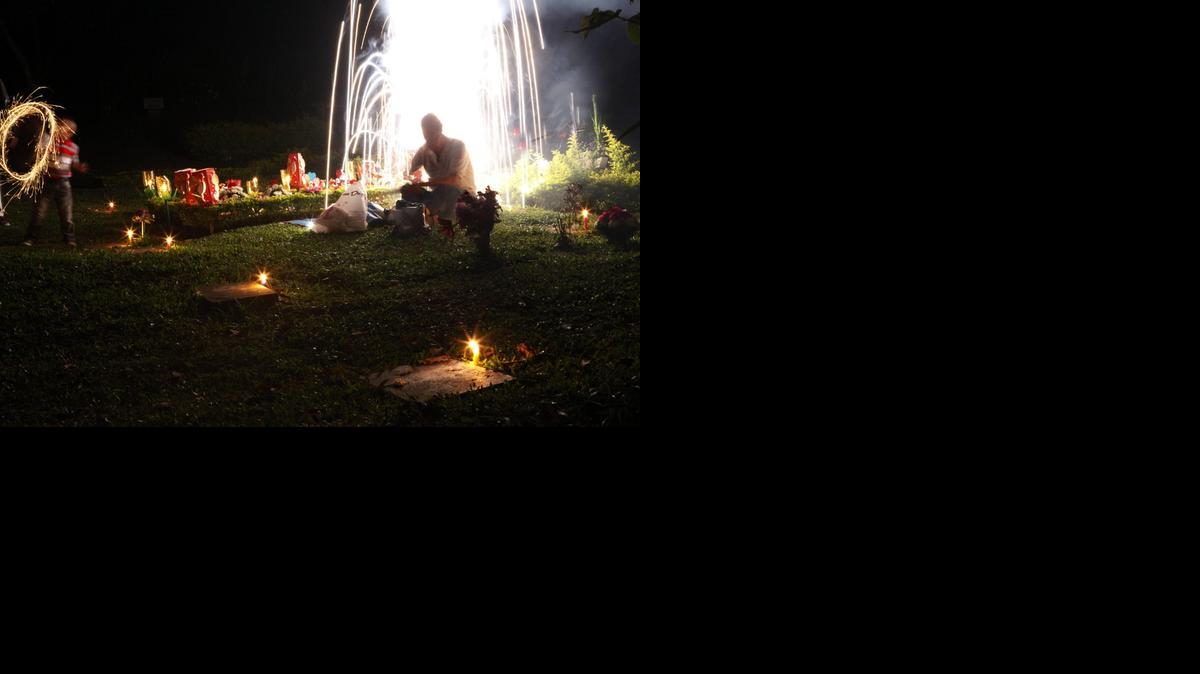 
Una familia enciende velas junto a una tumba durante la "Noche de las velitas" hoy, domingo 07 de diciembre de 2014, en un cementerio de la ciudad de Cali (Colombia). La celebración se realiza en vísperas del Día de la Inmaculada Concepción y marca el comienzo de las fiestas de Navidad en el país. 
