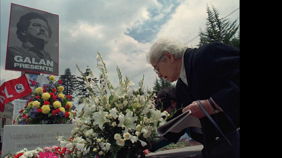 
Cecilia Sarmiento, la madre del candidato presidencial colombiano Luis Carlos Galán, coloca flores en su tumba en Bogotá, en 1996.
