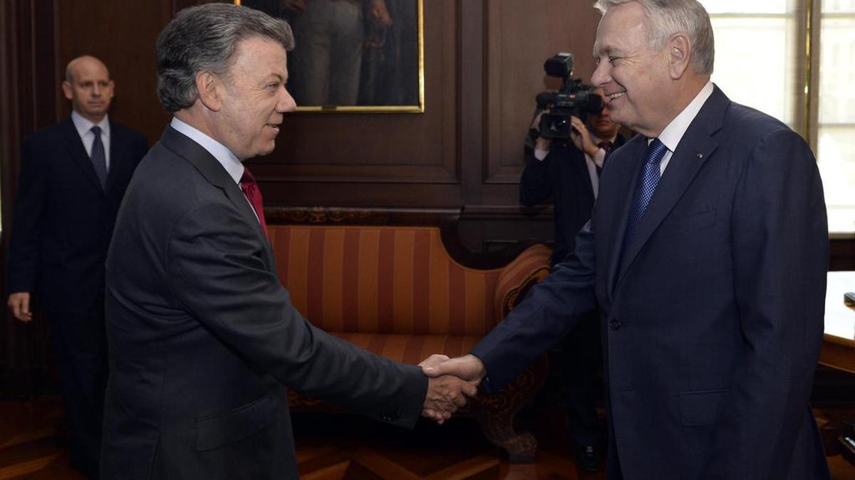 El presidente de Colombia, Juan Manuel Santos (i), estrecha la mano del canciller de Francia, Jean-Marc Ayrault, el 19 de diciembre de 2016, durante su encuentro en Bogotá.
