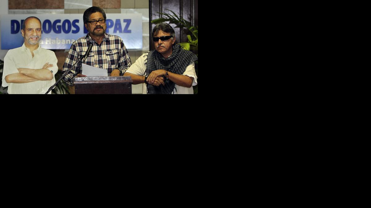 
El segundo jefe de las FARC, Iván Márquez (cen.), lee un comunicado junto a una imagen del guerrillero preso en EEUU, Simón Trinidad, el martes en el Palacio de Convenciones de La Habana. 
