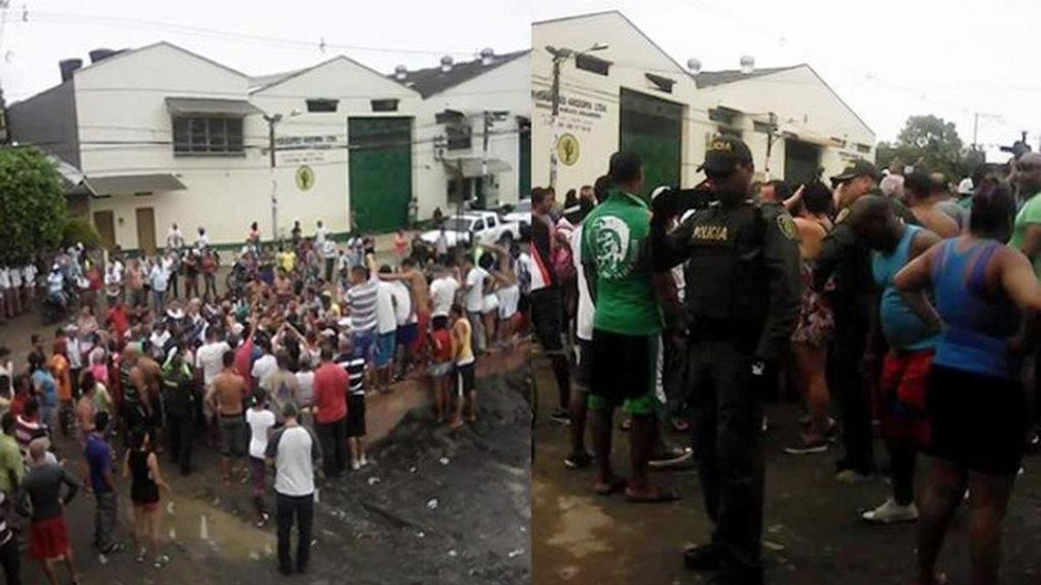 Migrantes y policías en dos fotos frente al almacén que sirve de albergue a cientos de cubanos varados en el municipio Turbo, en Colombia.