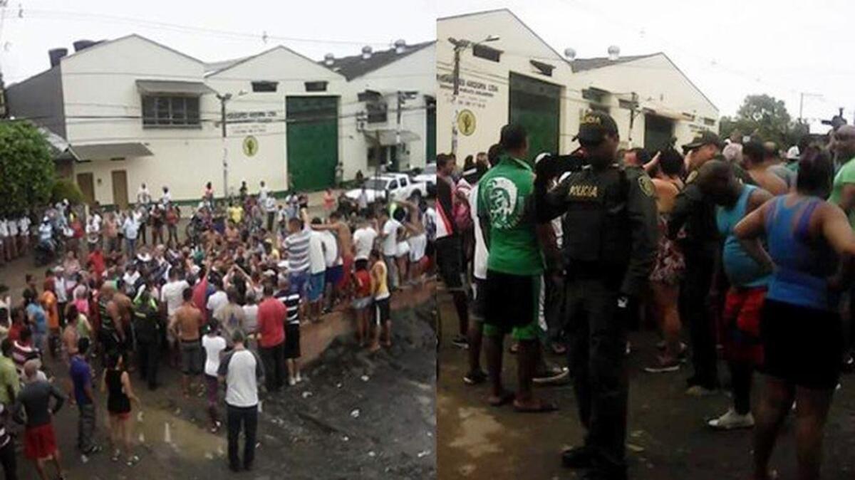 Migrantes y policías en dos fotos frente al almacén que sirve de albergue a cientos de cubanos varados en el municipio Turbo, en Colombia.