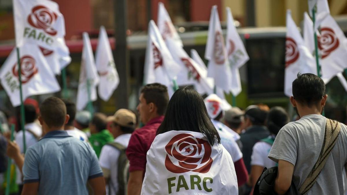 Los miembros y partidarios de las FARC marchan con banderas con el nuevo logo de las FARC, transformadas en un partido político después de su desarme, durante el cierre de su Congreso Nacional en Bogotá el 1 de septiembre de 2017.