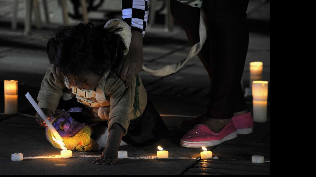 
Una niña enciende una vela cuando representantes de varias religiones se reunieron en la plaza Bolívar en Bogotá, el martes, para realizar una vigilia por la paz en Colombia.
