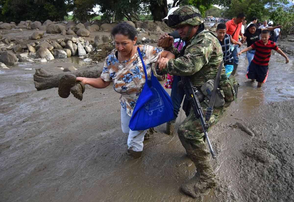 Un soldado ayuda a una mujer después de una avalancha del río La Paila el miércoles 08 de noviembre de 2017, en el municipio de Corinto, departamento del Cauca (Colombia).