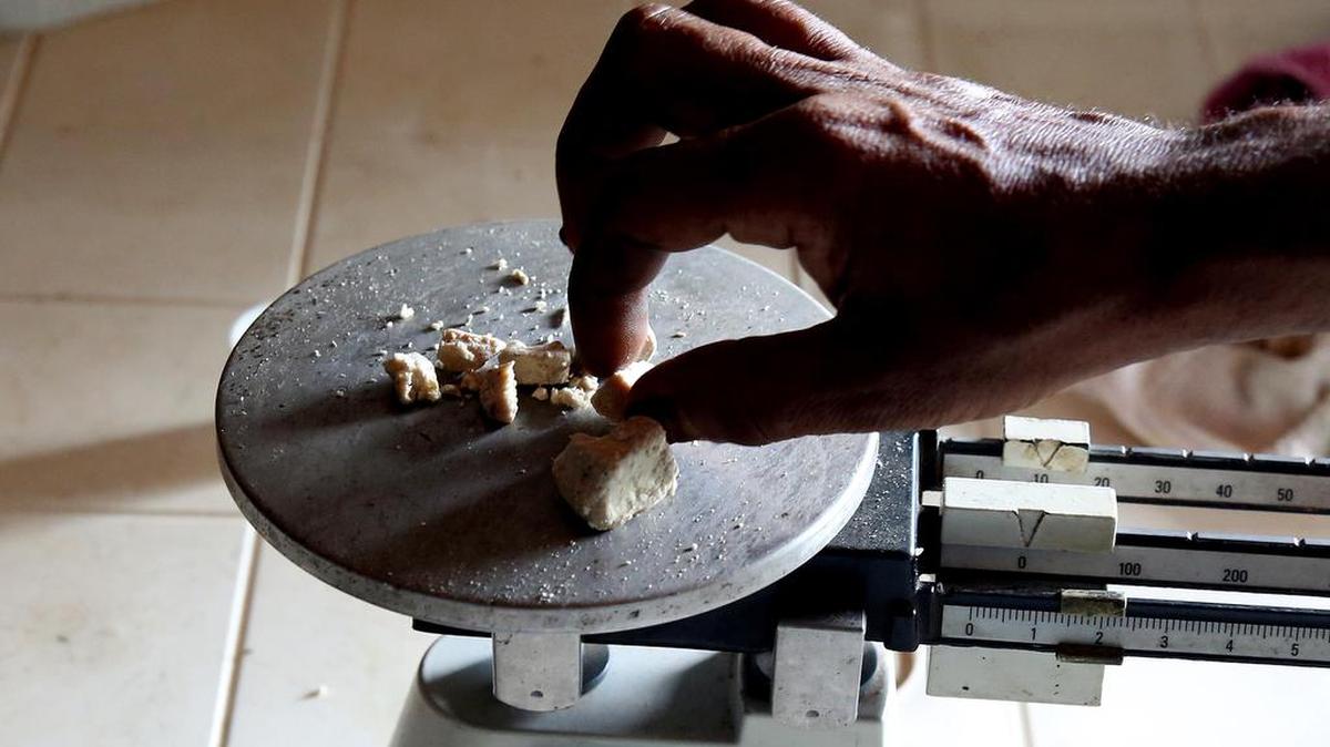 Fotografía del 16 de diciembre de 2016, de un hombre pesando pasta de coca para realizar un pago en Guerima (Colombia). "