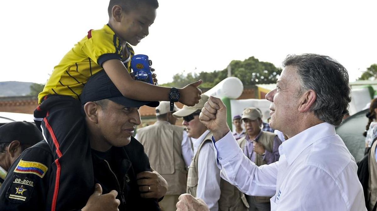 
El presidente colombiano Juan Manuel Santos saluda a un niño durante su visita el 29 de agosto a un refugio en Villa del Rosario, Colombia, donde se están quedando los ciudadanos deportados por Venezuela.

