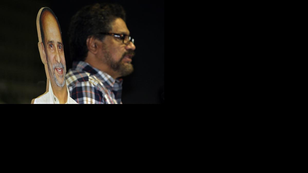 
 Fotografía donde se ve una imagen del integrante de las Fuerzas Armadas Revolucionarias de Colombia (FARC) preso en EEUU Ricardo Palmera, alias "Simón Trinidad" (i), junto al al segundo jefe de las FARC, Luciano Marín Arango (d), alias "Iván Márquez", mientras lee un comunicado a su llegada hoy, martes 23 de septiembre de 2014, al Palacio de Convenciones de La Habana (Cuba). El delegados del Gobierno de colombiano y representantes de las FARC inician una nueva ronda de reuniones en el marco de las conversaciones de paz. EFE/Alejandro Ernesto
