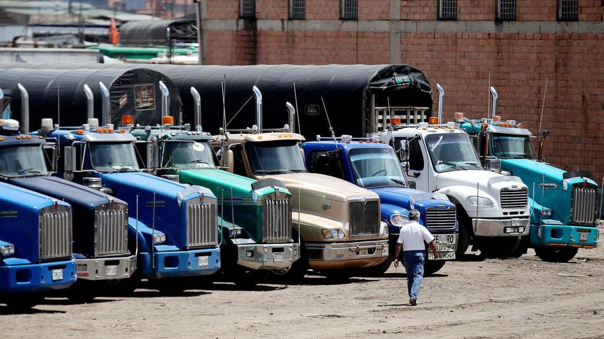 Un hombre camina junto a un grupo de camiones estacionados e miércoles 13 de julio de 2016, en un parqueadero para estos vehículos en Bogotá (Colombia).