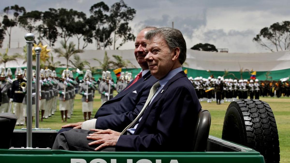 El presidente de Colombia, Juan Manuel Santos (d), junto con su ministro de Defensa, Luis Carlos Villegas (i), asisten a la ceremonia de transmisión de mando del nuevo director de la Policía Nacional, el general Jorge Hernando Nieto Rojas, hoy, sábado 20 de febrero de 2016, en la Escuela de Cadetes Francisco de Paula Santander de Bogotá (Colombia). Santos, defendió a las Fuerzas Armadas y dijo que no son responsables de la situación generada en la localidad de Conejo, en el departamento de La Guajira (norte), en donde varios delegados de las FARC en los diálogos de paz participaron el jueves pasado un acto armado de proselitismo.