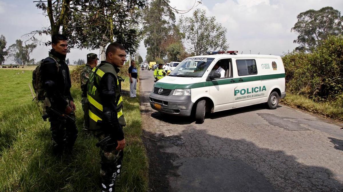 Miembros de la Armada y Policía de Colombia investigan en el lugar donde se detonó un artefacto explosivo al paso de un autobús de la Armada en los alrededores del aeropuerto de Guaymaral, a varios kilómetros al norte de Bogotá (Colombia), hoy, lunes 7 de marzo de 2016.
