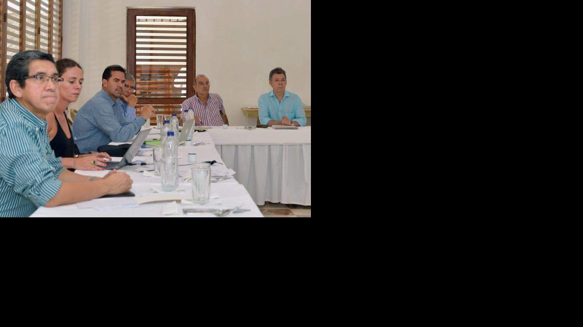 
El presidente de Colombia, Juan Manuel Santos (1 der.), en una reunión privada con el equipo gubernamental de negociaciones de paz en la Casa de Huéspedes del gobierno en Cartagena, el domingo. 
