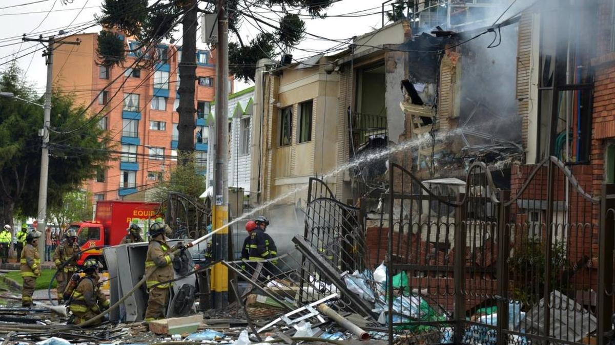 Bomberos apagan un incendio después de una explosión en una casa donde aparentemente funcionaba una compañía farmacéutica, en Bogotá, Colombia.
