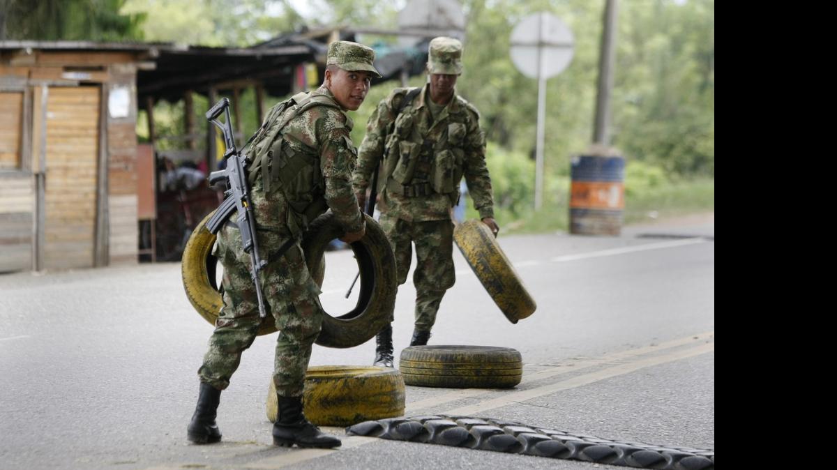 
Miembros del Ejército instalan un puesto de control el viernes, en una vía que une los departamentos del Cauca y Valle en el suroeste colombiano en Villa Rica. El gobierno colombiano propinó el más duro golpe militar a las FARC desde que hace 30 meses comenzaron los diálogos de paz en La Habana con un bombardeo que dejó 26 rebeldes muertos, lo que llevó hoy a esa guerrilla a suspender su cese el fuego unilateral e indefinido. 
