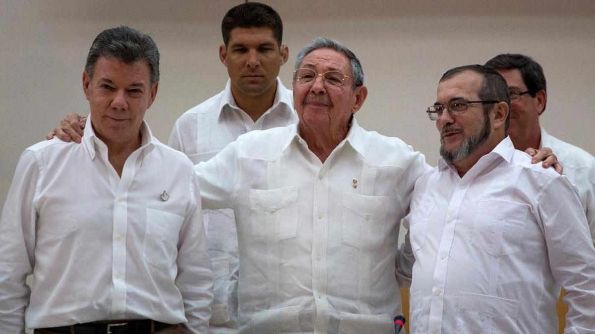 El presidente de Colombia, Juan Manuel Santos (izq.); el mandatario cubano, Raúl Castro, y uno de los comandantes de FARC,Timoleon Jiménez, se abrazan en La Habana después de sortear un importante escollo en las negociaciones de paz.