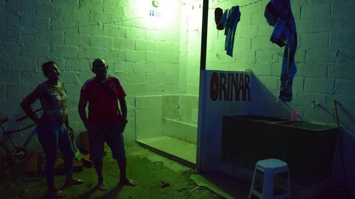 Dayana y Gabriel Sanchez se dejan fotografiar en penumbras en la parte trasera del burdel Show Malilo, en Arauca, en la frontera de Venezuela y Colombia.