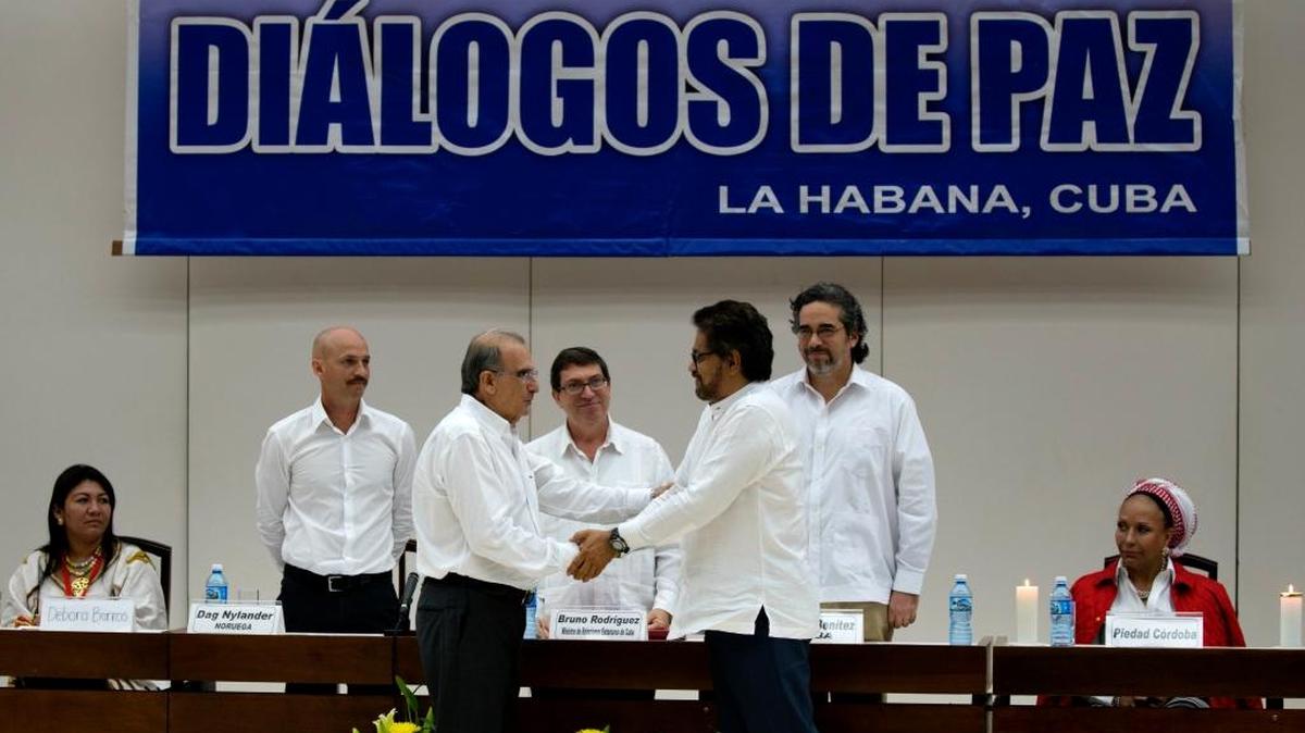 Humberto de la Calle (izq.), líder de la delegación de paz del gobierno de Colombia, saluda a Iván Márquez, jefe negociador de las FARC, tras firmar un acuerdo sobre las víctimas del conflicto armado, en el 2015.