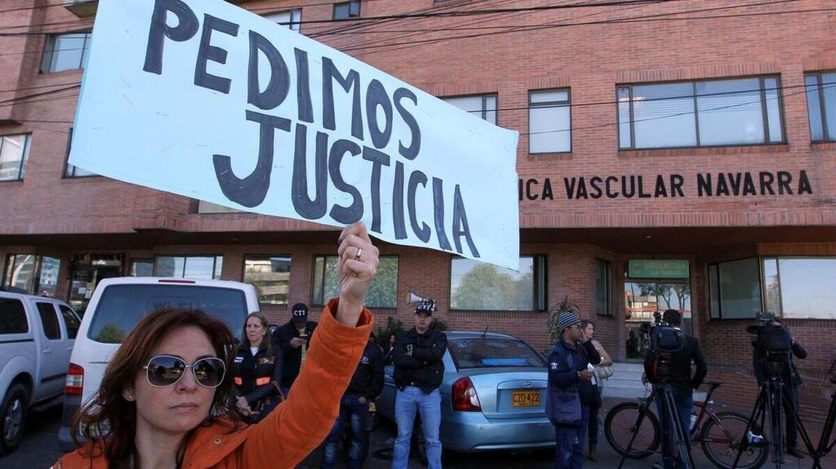 Un grupo de personas protesta frente a la clínica Navarra donde se encontraba el supuesto violador y asesino de la niña Yuliana Andrea Samboni Muñoz el martes 6 de diciembre de 2016, en Bogotá (Colombia).
