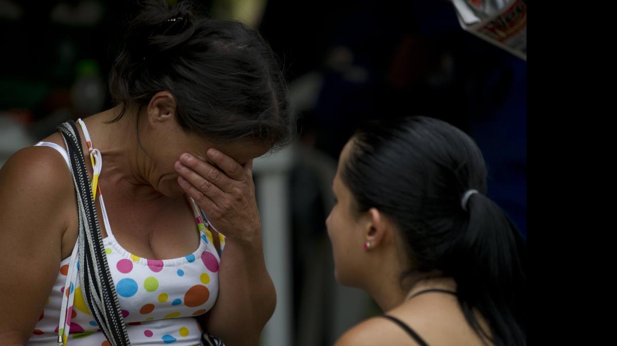 
Una mujer llora mientras espera noticias de los rescatistas que tratan de salvar la vida a 15 mineros atrapados en una mina artesanal de oro en Riosucio, Colombia. 
