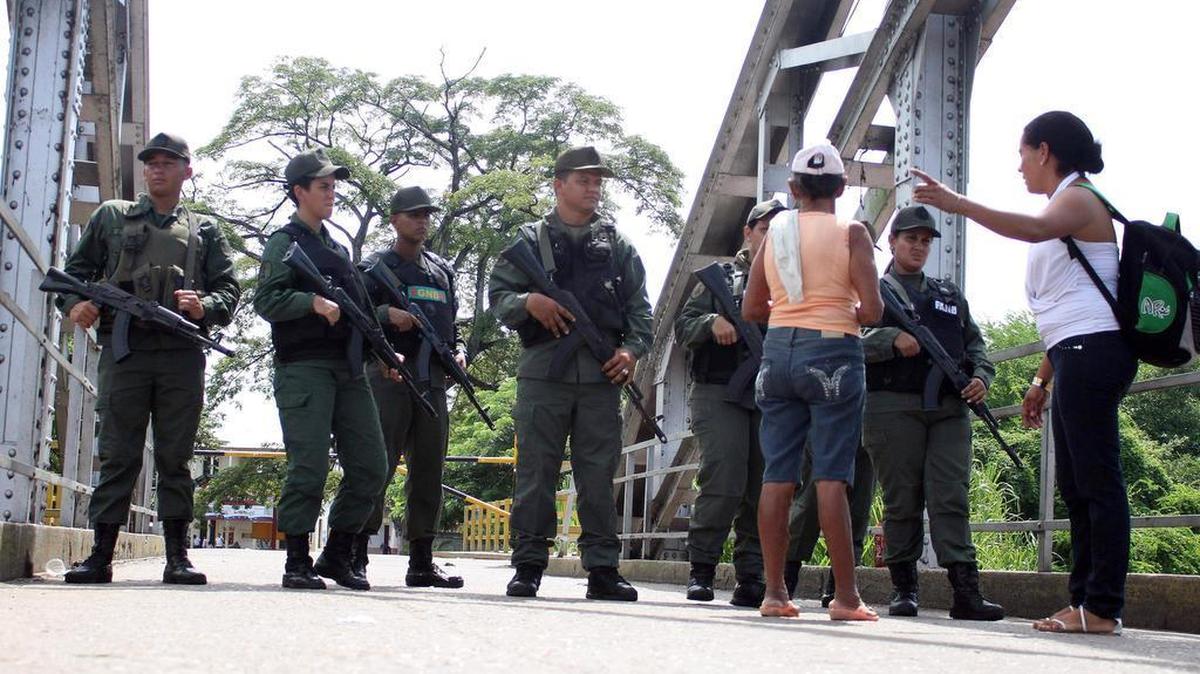 
Ciudadanos colombianos hablan con guardias venezolanos en el Puente La Unión buscando pasar la frontera hoy, sábado 29 de agosto de 2015, en Puerto Santander (Colombia). El estado de excepción que el presidente de Venezuela, Nicolás Maduro, amplió ayer a cuatro municipios fronterizos provocó hoy otro éxodo de colombianos que, atemorizados ante la posibilidad de ser deportados, regresan a su país a través de rutas alternativas. 

