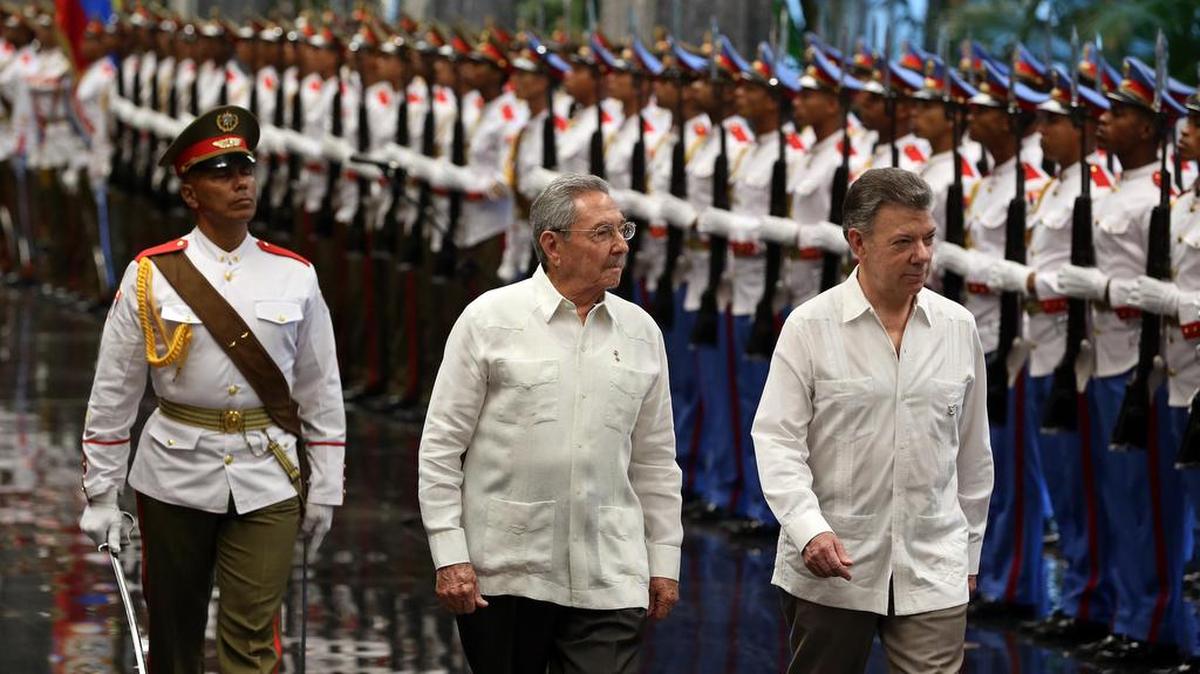 El gobernante de Cuba, Raúl Castro (i) y el presidente de Colombia, Juan Manuel Santos (d), pasan revista a las tropas formadas para la ceremonia oficial de recibimiento el lunes 17 de julio de 2017, en el Palacio de la Revolución de La Habana (Cuba).