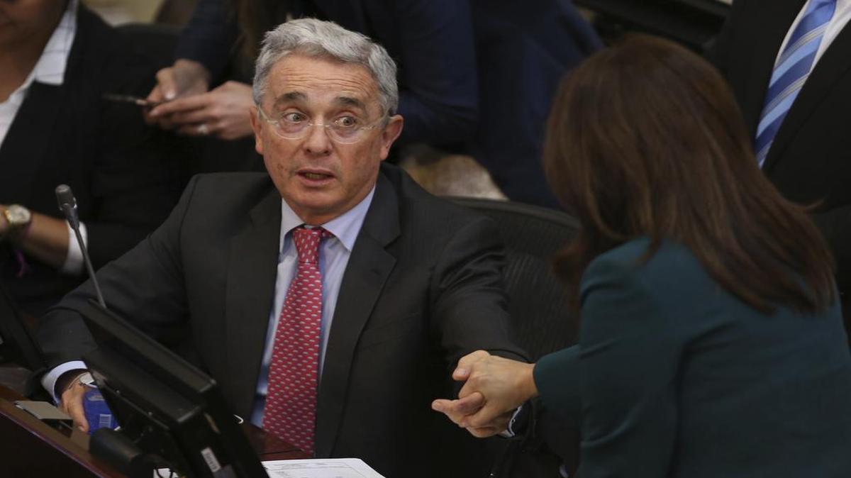 El ex presidente colombiano Alvaro Uribe conversa con una senadora en el pleno de la cámara alta en octubre del 2016.