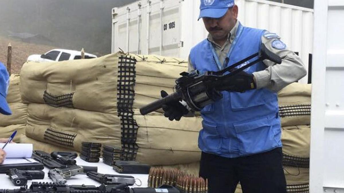 En esta foto publicada el 13 de junio por la misión de la ONU en Colombia, un miembro de la misión de monitoreo para el proceso de paz colombiano sostiene un arma entregada por los rebeldes de las FARC en el Campamento temporal de La Elvira en Buenos Aires, en el sur de Colombia.