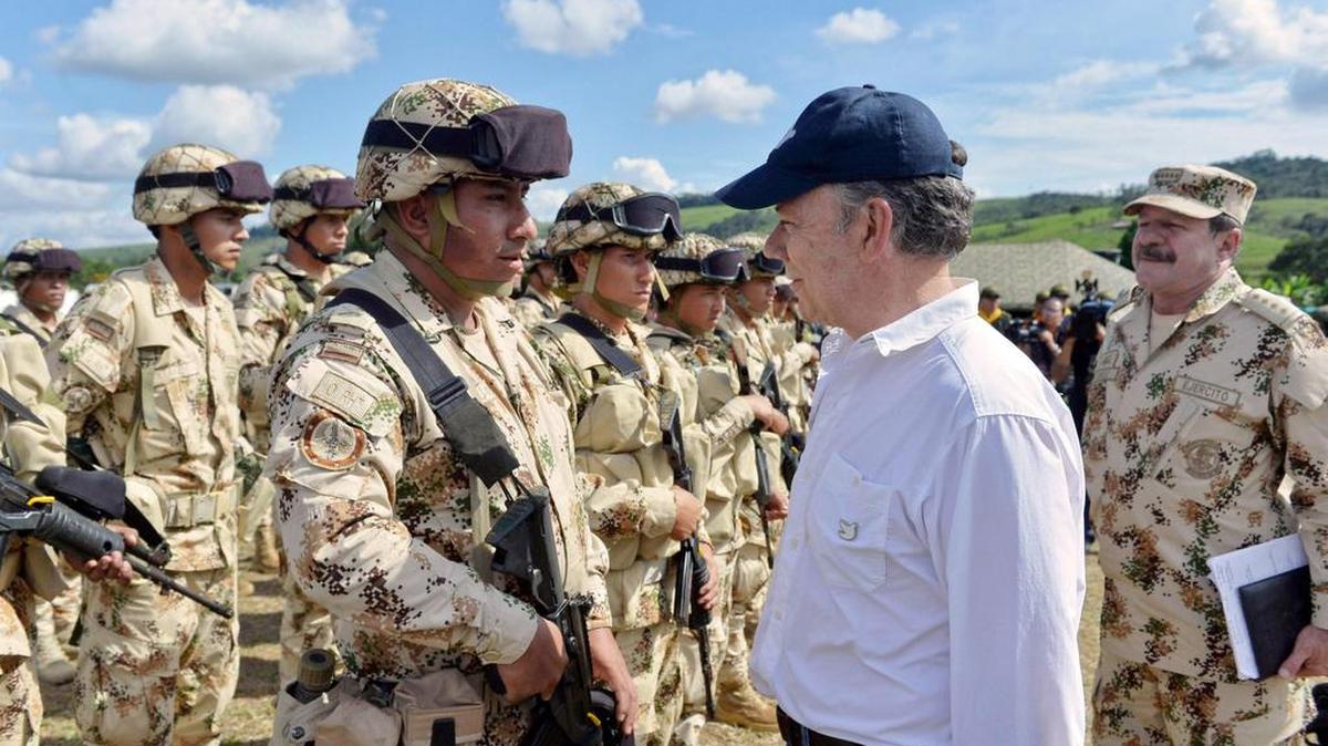 El presidente de Colombia, Juan Manuel Santos, saluda a los miembros del Comando Conjunto de Monitoreo y Verificación durante su visita a uno de los campamentos vigilados y verificados por la ONU que recibirán a los miembros de la guerrilla de las FARC.