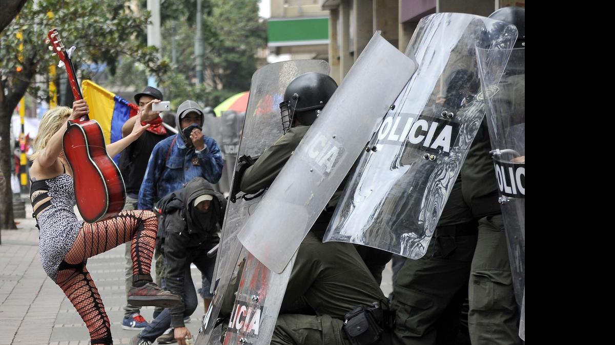 
Una manifestante confronta violentamente a la policía antimotines durante el Día del Trabajo en Bogotá, Colombia.

