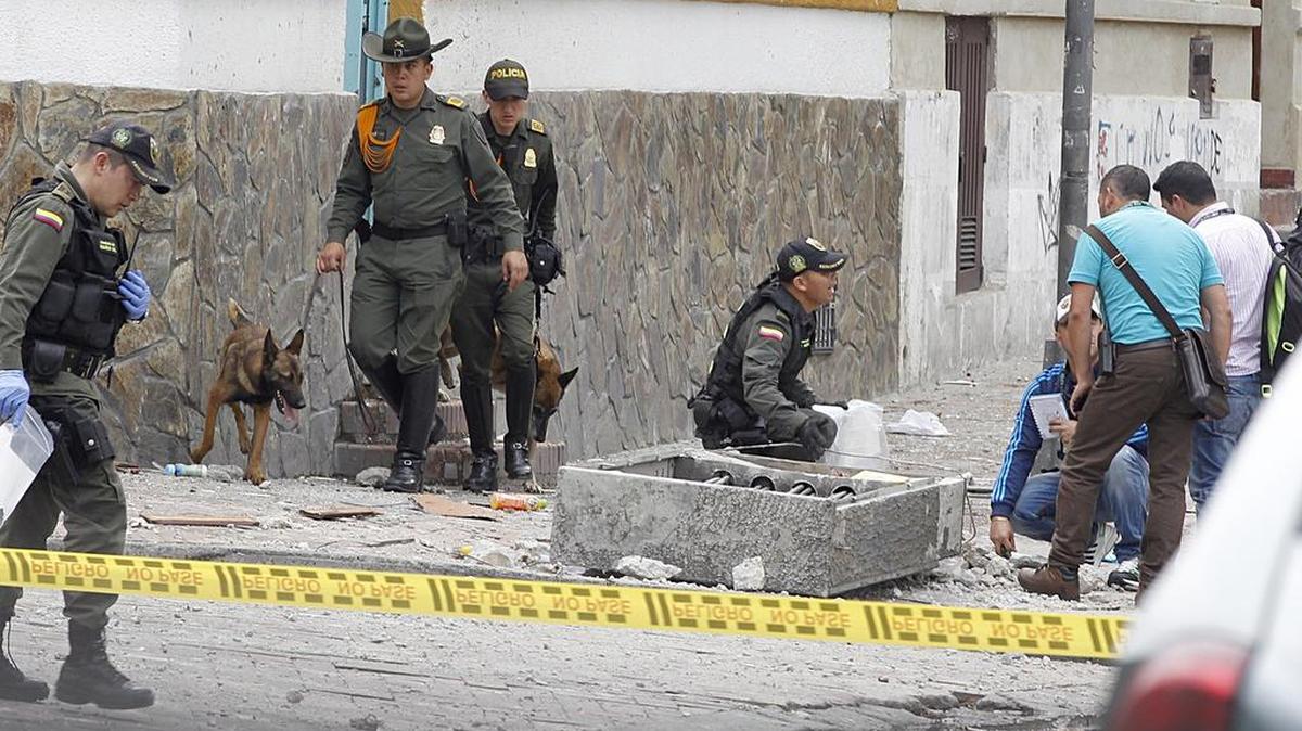 Los miembros del Departamento de Policía de Bogotá inspeccionan y se reúnen pruebas de los daños causados por una explosión en el barrio de la Macarena, en Bogotá Colombia, que dejó un policía fallecido, el domingo 19 de febrero 2017.