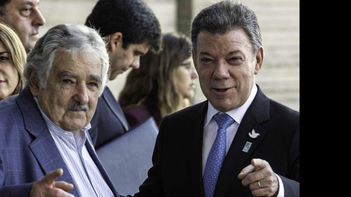 
El entonces presidente de Uruguay, José Mujica (izq.), y su homólogo colombiano Juan Manuel Santos, conversan duranto una cumbre presidencial en Brasilia, el 16 de julio de 2014. 

