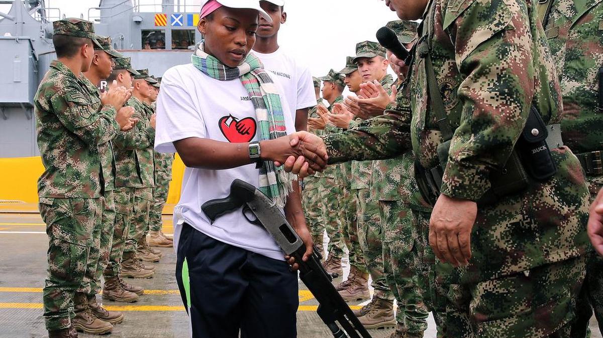 Una mujer guerrillera del Ejercito de Liberación Nacional (ELN) entrega su arma al Comandante General de las Fuerzas Militares Juan Pablo Rodríguez Barragán (d) el martes 18 de octubre de 2016, en Buenaventura (Colombia).