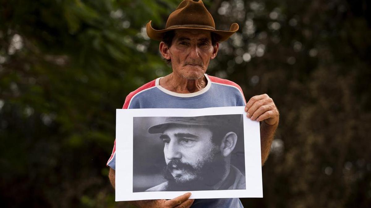 Aldo, 63 años, sostiene una imagen del fallecido líder de la revolución cubana, Fidel Castro, antes del paso de la caravana con sus cenizas el jueves 1 de diciembre de 2016, en Santa Clara (Cuba).