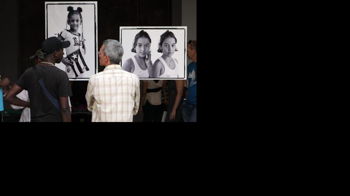 
Asistentes observan fotos de la exposición “Cómo lo vemos a usted”, del fotógrafo estadounidense Jeffrey Cárdenas y la cubana Yanela Piñeiro, el viernes 26 de diciembre de 2014, en el Museo Nacional de Bellas Artes de La Habana.

