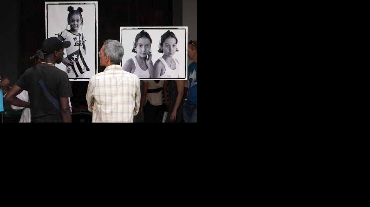 
Asistentes observan fotos de la exposición “Cómo lo vemos a usted”, del fotógrafo estadounidense Jeffrey Cárdenas y la cubana Yanela Piñeiro, el viernes 26 de diciembre de 2014, en el Museo Nacional de Bellas Artes de La Habana.
