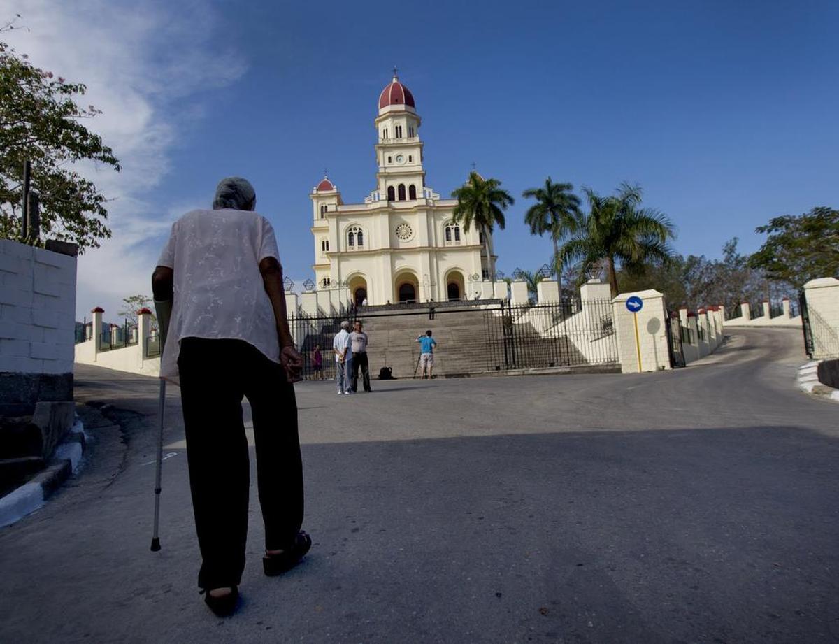 Una anciana camina por la calle hacia la estatua original de Nuestra Señora de la Caridad, ubicada en el Santuario de El Cobre el domingo 25 de marzo de 2012.