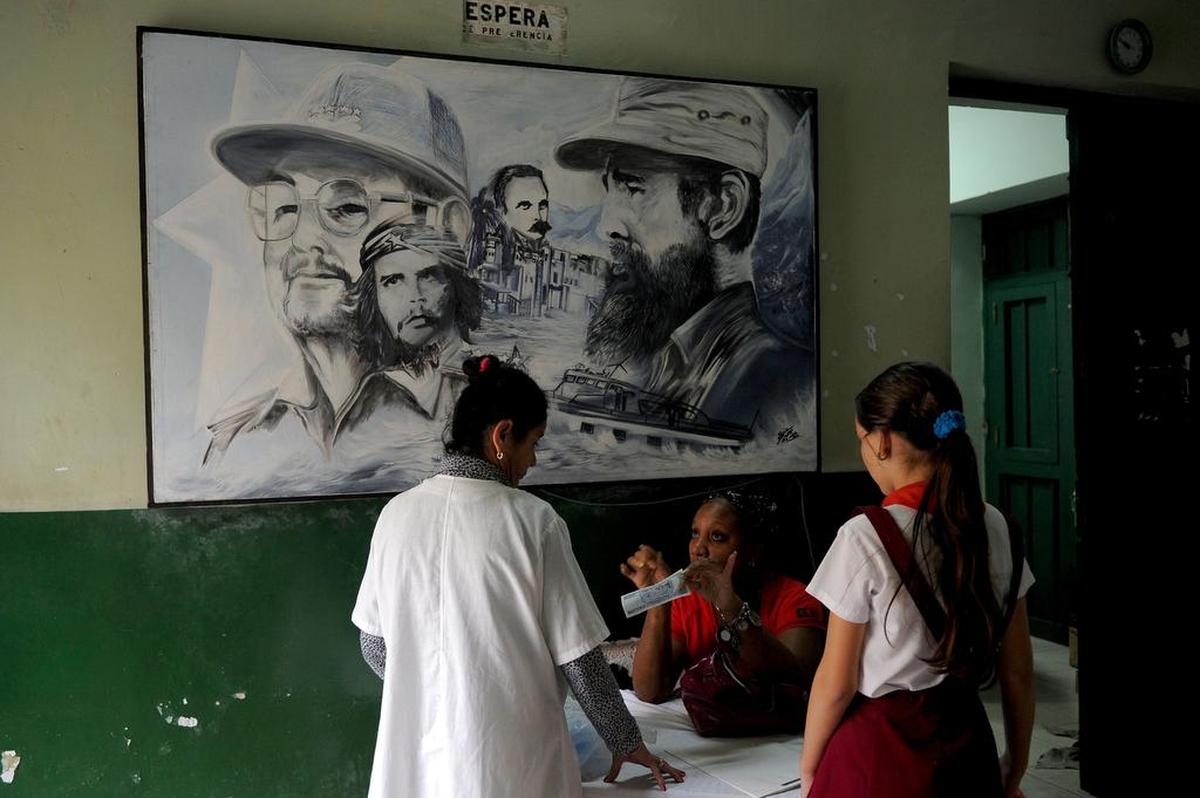 A framed drawing of Fidel Castro with brother Raúl, at left, and other Cuban Revolutionary leaders hangs in a Havana school in 2017.