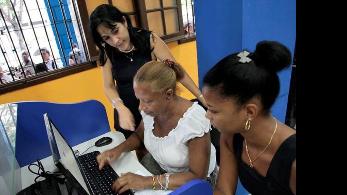 
Una empleada de la empresa estatal ETECSA ayuda una cliente en un cibercafé, en La Habana, en el 2013. 
