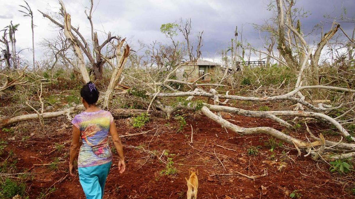 Una mujer camina cerca de su casa dañada por el huracán Matthew en la municipalidad de Maisi, en la provincia de Guantánamo, Cuba, el 21 de octubre de 2016.
