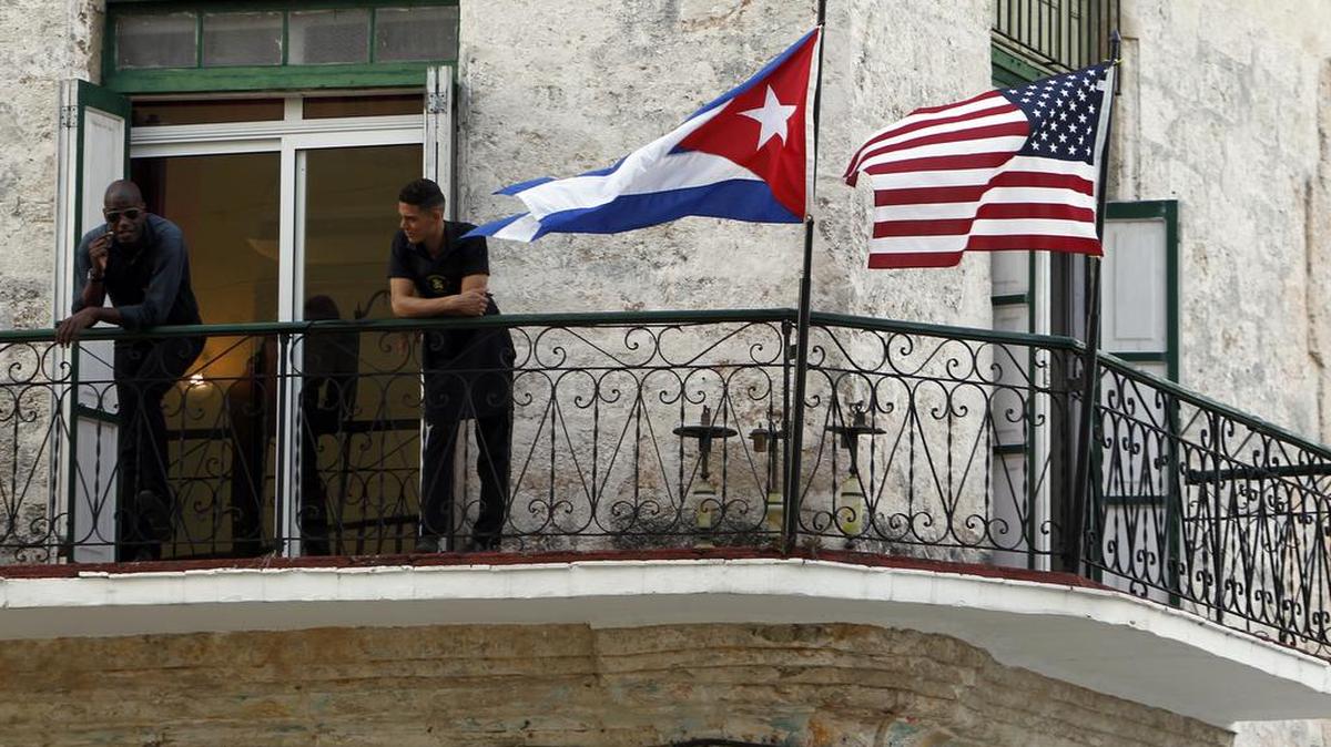 Dos jóvenes cubanos conversan junto a las banderas de Estados Unidos y Cuba el jueves 17 de marzo del 2016, en La Habana (Cuba). Barack Obama, emprenderá a Cuba en una visita oficial que realizará entre los días 20 y 22 de marzo, tras el restablecimiento de la normalización de relaciones diplomáticas a partir de diciembre de 2014.