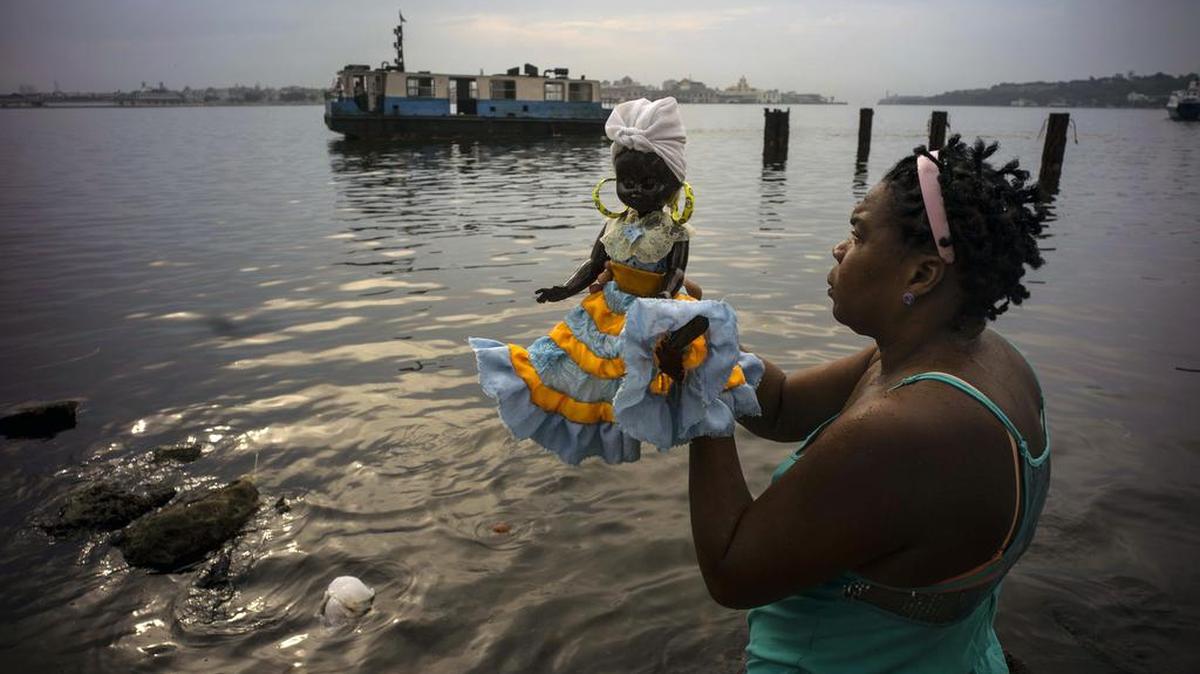 
Una seguidora de la religión yoruba sostiene una muñeca que representa a Yemayá, antes del comienzo de una procesión el día de la Virgen de Regla, localidad habanera ubicada al otro lado de la Bahía de La Habana, Cuba, en una imagen del 7 de septiembre.


