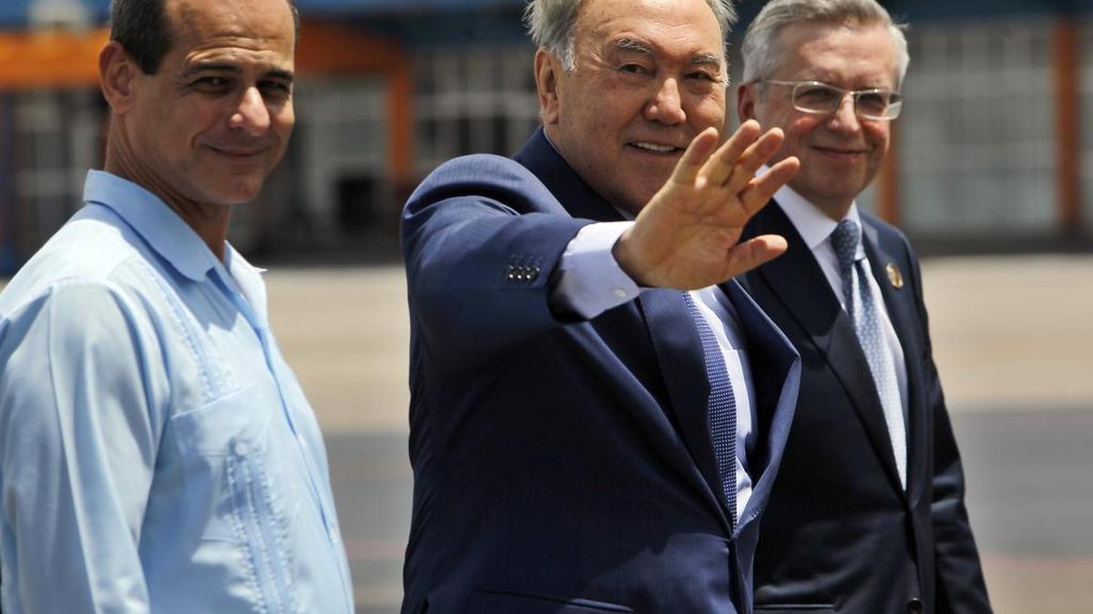 El presidente de la República de Kazajistán, Nursultán Abishevich Nazarbáyev (cen.), saluda junto al vicecanciller cubano Rogelio Sierra (izq.), a su llegada el sábado al aeropuerto internacional José Martí, en La Habana.