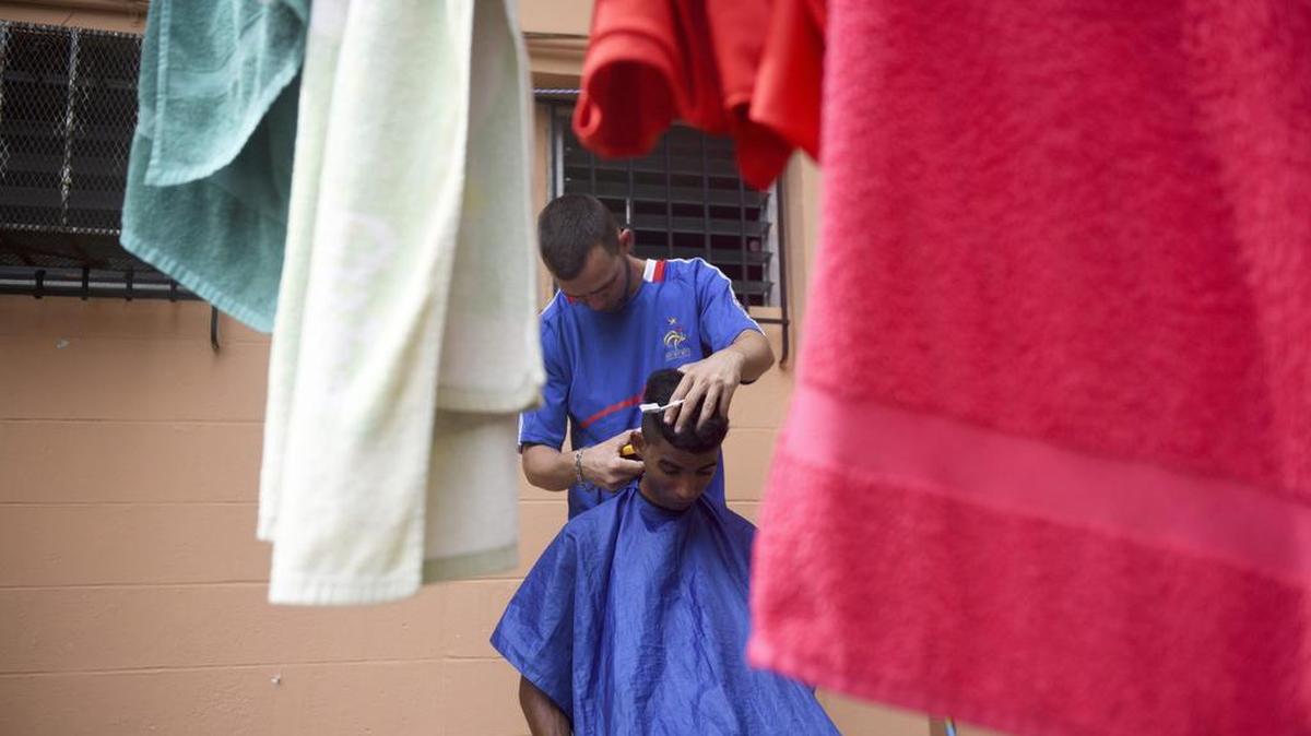 Un barbero le corta el cabello a un inmigrante cubano en un refugio de la organización Cáritas el martes 20 de septiembre, en Ciudad de Panamá.