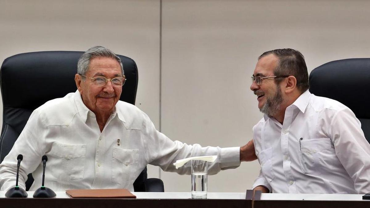 El líder de las FARC, Rodrigo Londoño Echeverri, alias "Timochenko" (d), habla con el gobernante de Cuba, Raúl Castro (i), en La Habana (Cuba) el jueves 23 de junio de 2016.